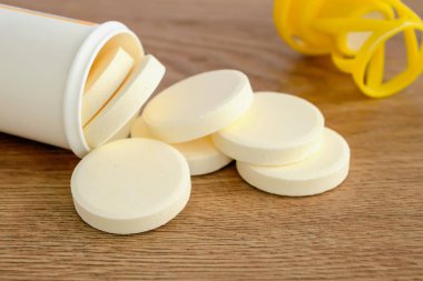 Çözünür efervesan vitamin hapları plastik botte dökülen.
