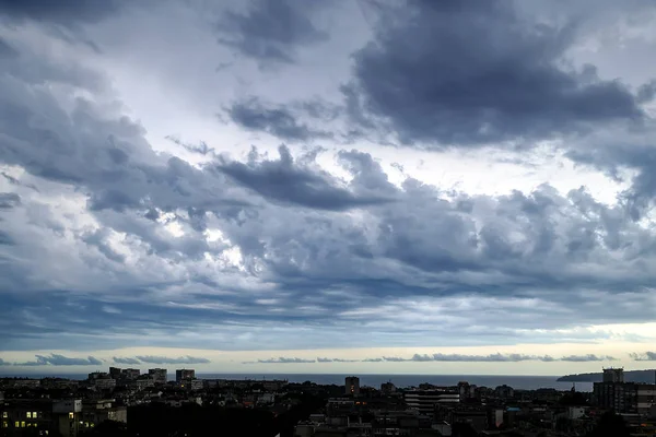 Cielo oscuro y tormentoso sobre una ciudad costera en la noche de verano. Paisaje escénico dramático . — Foto de Stock