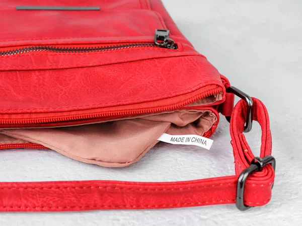 Label Made in China inside of a small red casual handbag