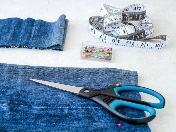 Making shorts out of blue jeans. Shorten the jeans.