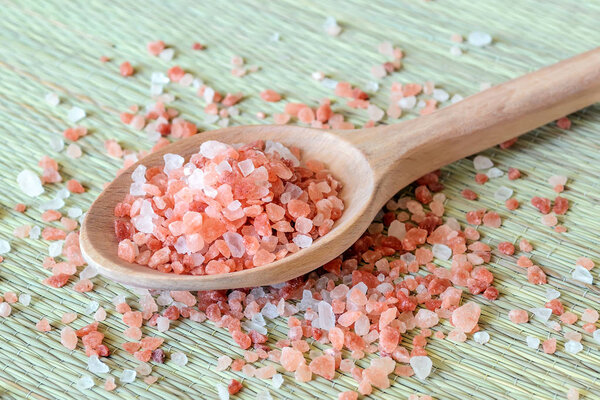 Wooden spoon with large crystals of pink himalayan salt.