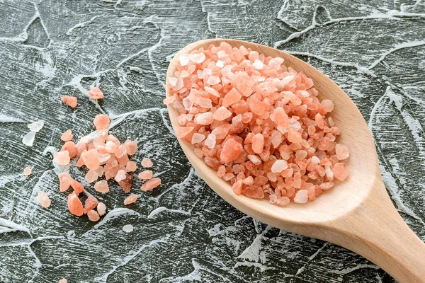 Cuchara de madera con grandes cristales de sal rosa himalaya . — Foto de Stock