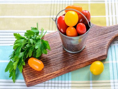 Küçük bir metal kova olgun çok renkli kiraz domates.