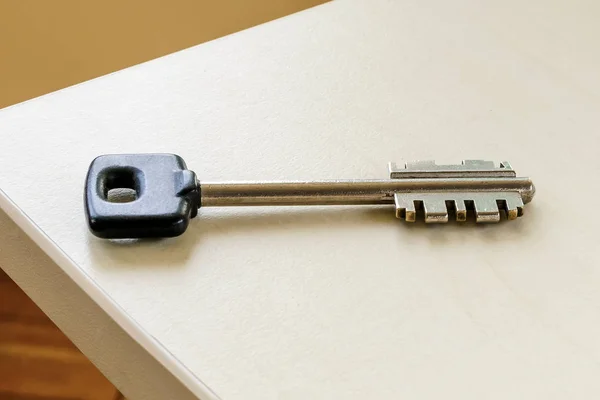 Una llave grande con la cabeza negra sobre una mesa en una habitación . —  Fotos de Stock