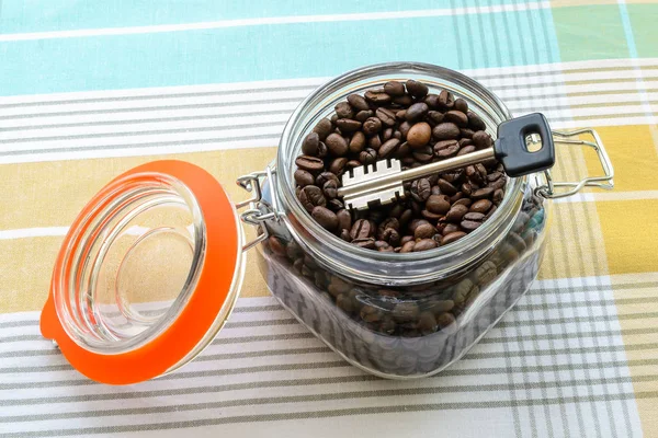 Large key in a clip top glass jar with coffee beans