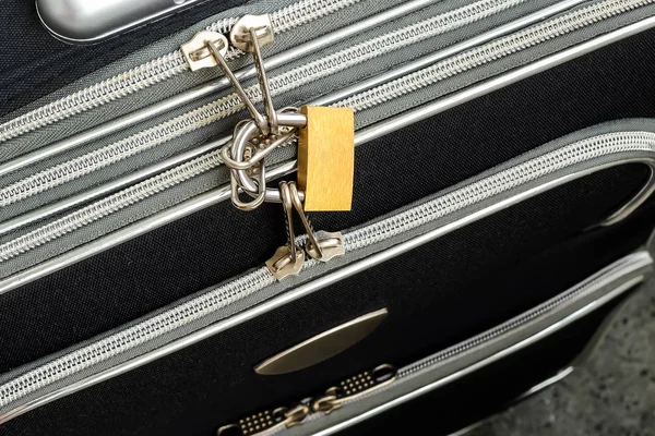 Reißverschlüsse mit Vorhängeschloss an schwarzem Reisekoffer verriegelt. — Stockfoto