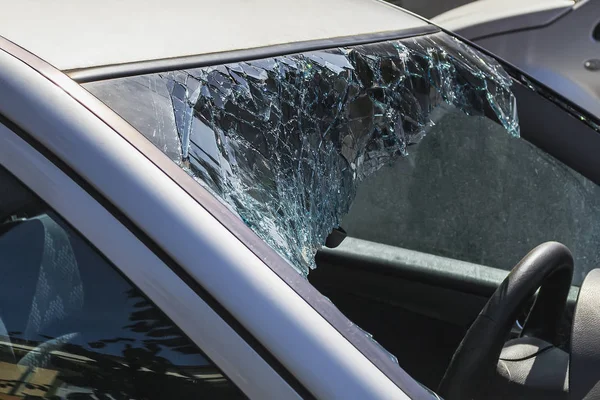 Stationary car with broken windshield. Theft from the car.