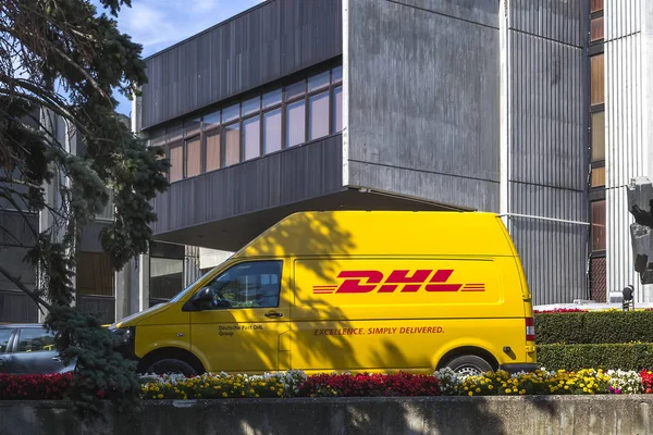 Gelbes dhl-Auto geparkt in der Nähe des städtischen Verwaltungsgebäudes. — Stockfoto