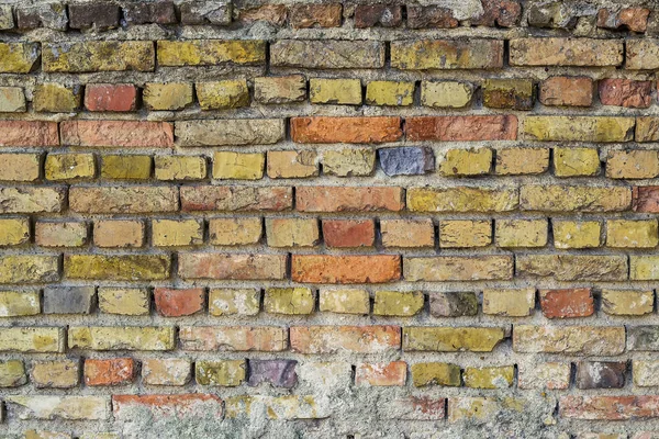 Superficie de la pared rugosa envejecida de ladrillos agrietados rojos amarillos y grises —  Fotos de Stock
