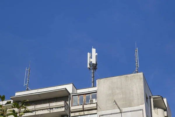 Antennes van cellulaire communicatie op een dak van een woongebouw — Stockfoto