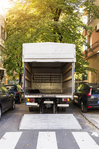 Camión de reparto de muebles abierto en una calle de la ciudad. Furgoneta en movimiento vacía — Foto de Stock