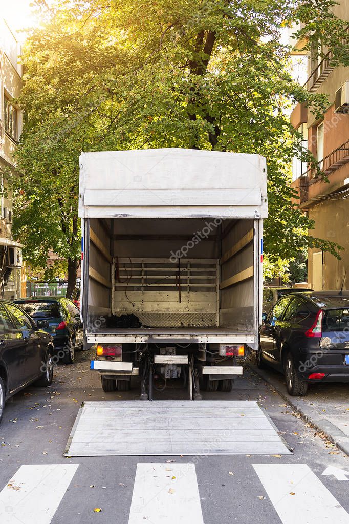 Open furniture delivery truck on a city street. Empty moving van