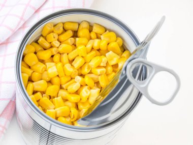 Konserve kutusunda mısır konservesi ve masada çekme sekmesi..