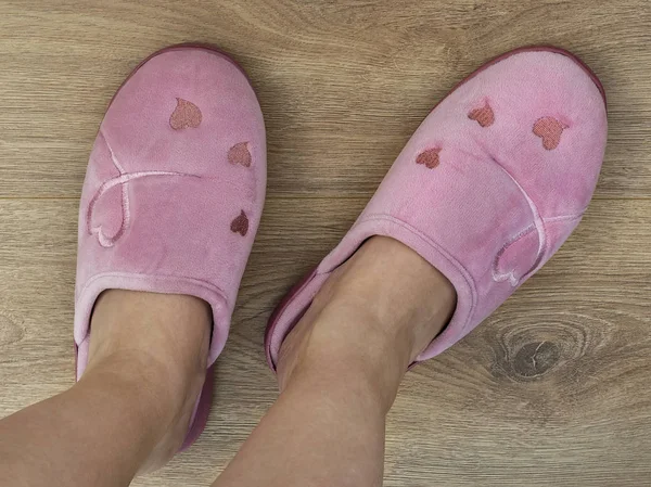 女人的脚穿着粉红色的家用拖鞋。 舒服而温暖. — 图库照片