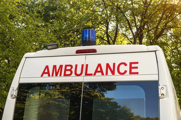 Stationary white ambulance car with a blue light on a roof.