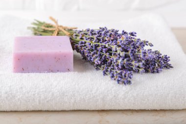 Taze kokulu lavanta ve mor lavanta sabunu banyoda beyaz bir havlu üzerinde. Ev yapımı spa, cilt bakımı ve kozmetoloji konsepti. Ön görünüm.