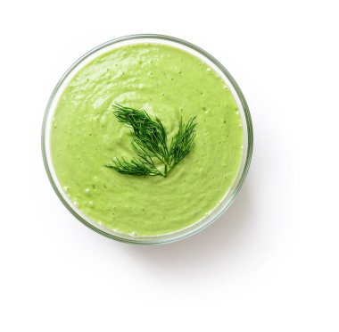 Beyaz arka planda izole edilmiş cam bir kasede taze soğuk salatalık çorbası püresi. Çiğ yemek diyet çorbası Yunan yoğurdu, çiğ salatalık, avokado, dolma biber, dereotu ve sarımsak. Üst görünüm.