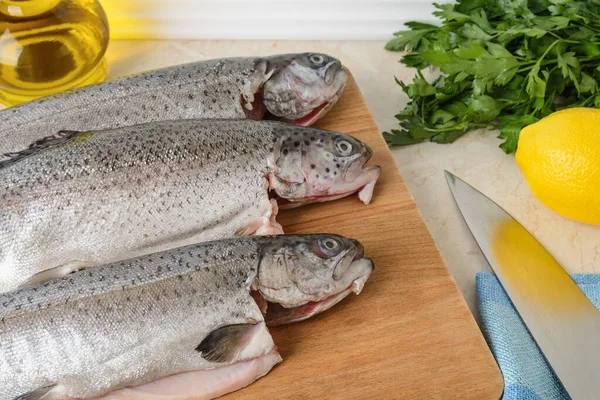 Primer Plano Tres Peces Trucha Destripados Crudos Una Tabla Cortar — Foto de Stock