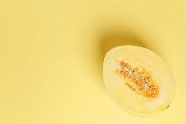 Sarı, olgun, kavunlu kavunun yarısı sarı arka planda. Vejetaryen, çiğ gıda diyeti ve sağlıklı beslenme konsepti. Tatlı meyveler ve meyveler. Uzayı kopyala Üst görünüm.