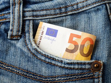 Kot pantolonun cebinde 50 euro banknot var. Zenginlik, nakit tasarrufu, gelir ve gider hesapları. Yakın plan..