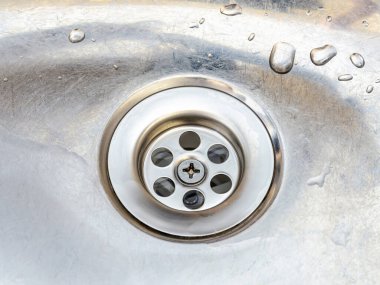 Eski metal mutfak lavabosunda su damlaları olan yeni bir süzgeç. Beyaz pvc plastik ve paslanmaz çelikten yapılmış yerli tesisat tesisatlarını kurun, temizleyin ve tamir edin. Üst görünüm.