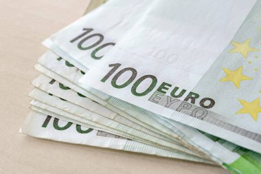 Yakın plan 100 Euro 'luk banknot yığını. Zenginlik ve ücretler, nakit tasarrufları, gelir ve gider hesapları. Ön görünüm.