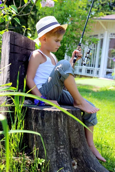 Junge Sitzt Mit Angelrute Der Hand Auf Einem Baumstumpf — Stockfoto