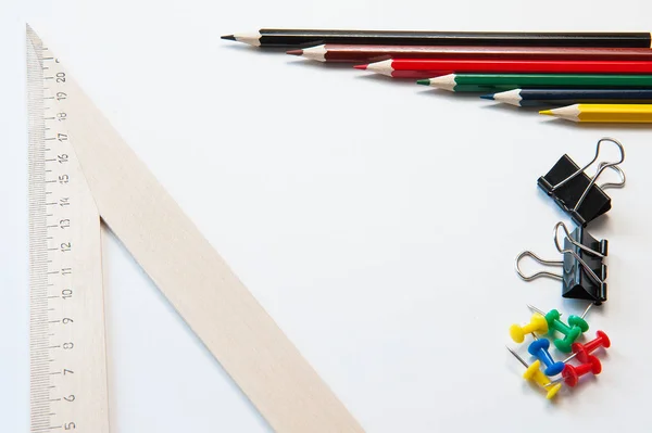 Цветные карандаши и деревянная линейка и канцелярские принадлежности на белом фоне. Несколько расикананда — стоковое фото