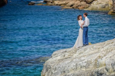 Bir adamla bir kız deniz kenarında buzlu ayakta.