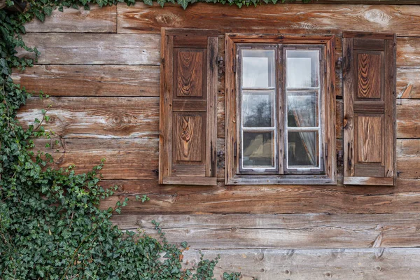 La vieja ventana de la vieja casa de madera. Fondo de paredes de madera — Foto de Stock
