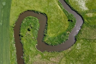 Yeşil tarladaki kıvrımlı nehrin hava manzarası