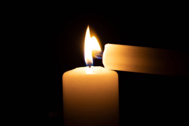 Büyük bir mumun yanında yanan küçük bir mum.