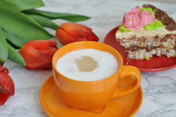 cup of coffee and cake with beautiful tulips