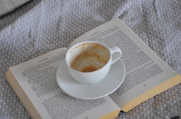 empty cup of coffee and book