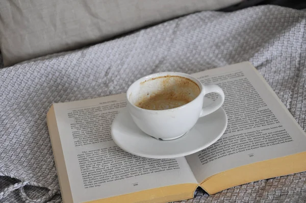empty cup of coffee and book