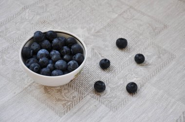 Taze yaban mersinleri bir kase içinde bir masa örtüsü üzerinde