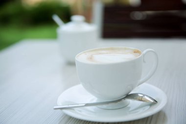 Ahşap beyaz masa açık arka plan üzerinde kahve