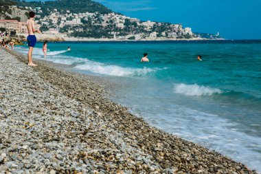 Nice, Fransa - 26 Haziran 2017: Akdeniz sahilinde güneşli havanın tadını çıkaran insanlar. Avrupa, Fransa