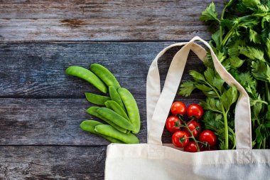 Eko alışveriş çantası ile taze organik sebze ve salata ahşap arka plan üzerinde üst görünüm, düz Lay