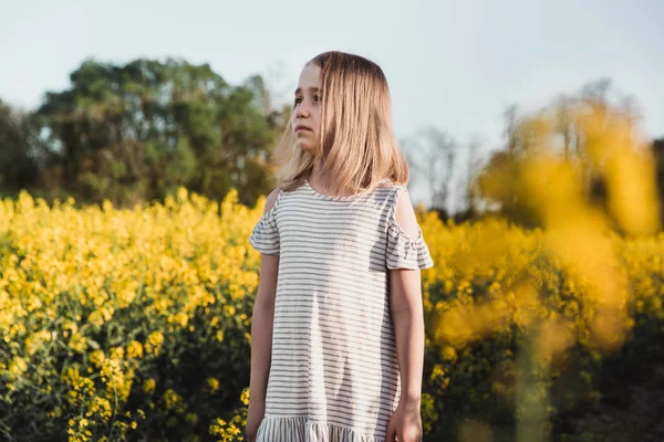 Menina caminhando em um campo de colza — Fotografia de Stock