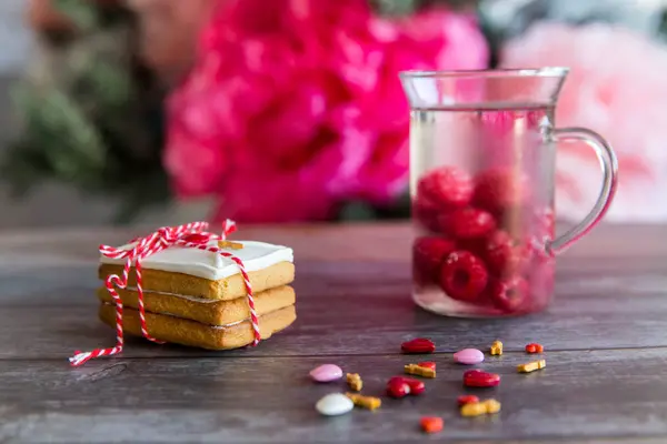 Feltöltési és fa háttér-rózsaszín szív és kap malina itallal jegesedés meglepetés cookie-k sütés — Stock Fotó