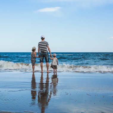 baba ve iki kızı sahilde ayakta, Akdeniz