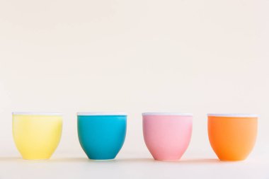 Pastel arka plan üzerinde renkli yumurta bardak, kopya alanı. Paskalya minimal kavramı