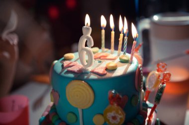 Koyu arka plan dekor şekerler ile mumlar ve 6 yaş mum yanan ile doğum günü pastası