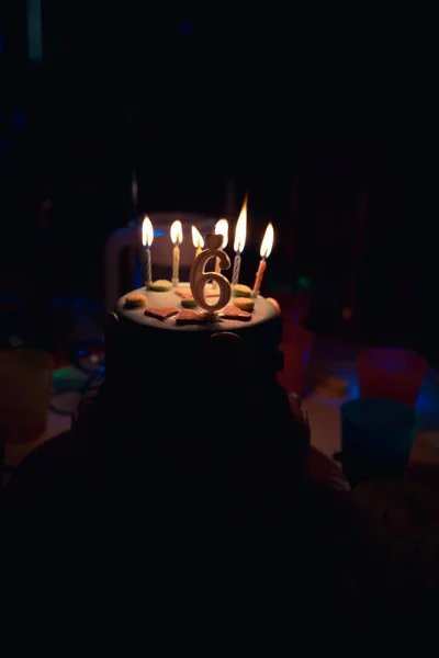生日蛋糕与燃烧的蜡烛和年龄6蜡烛在黑暗的背景与糖果在装饰 — 图库照片