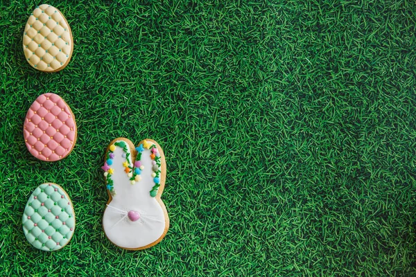 Osterkomposition mit Osterkeksen Eier nad Hasen auf grünem Gras Hintergrund. Osterkonzept mit Kopierraum. flache Lage — Stockfoto