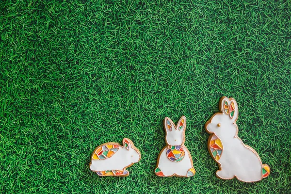 Osterkomposition mit Osterkeksen Hasen auf grünem Gras Hintergrund. Osterkonzept mit Kopierraum. Flache Lage — Stockfoto