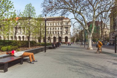 Budapeşte, Macaristan - 03 Nisan 2019: Macaristan Parlamentosu yakınlarında yürüyen ve dinlenen turistler ,Budapeşte