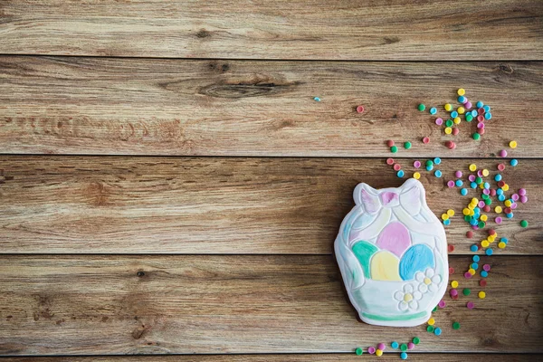 Süßigkeiten, Gebäck für den Ostertisch. Ostern handbemalte Lebkuchen mit farbigen Streuseln auf Holzgrund — Stockfoto