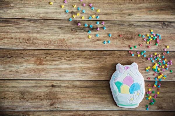 Süßigkeiten, Gebäck für den Ostertisch. Ostern handbemalte Lebkuchen mit farbigen Streuseln auf Holzgrund — Stockfoto